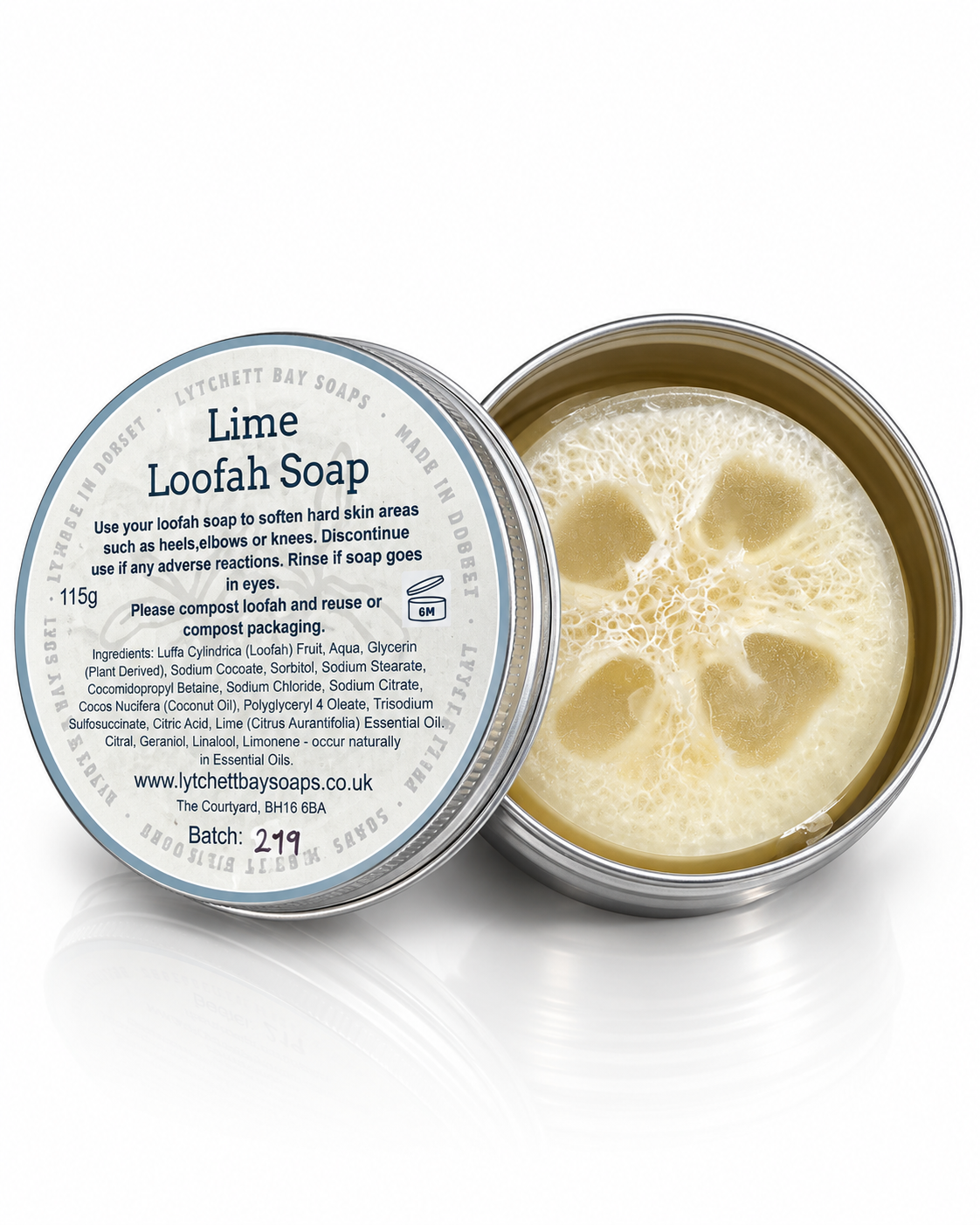 Two silver metal tins of Lytchett Bay Soaps Lime Loofah Soap, one closed with a white label and one open showing the pale yellow soap inside, on a white reflective background.
