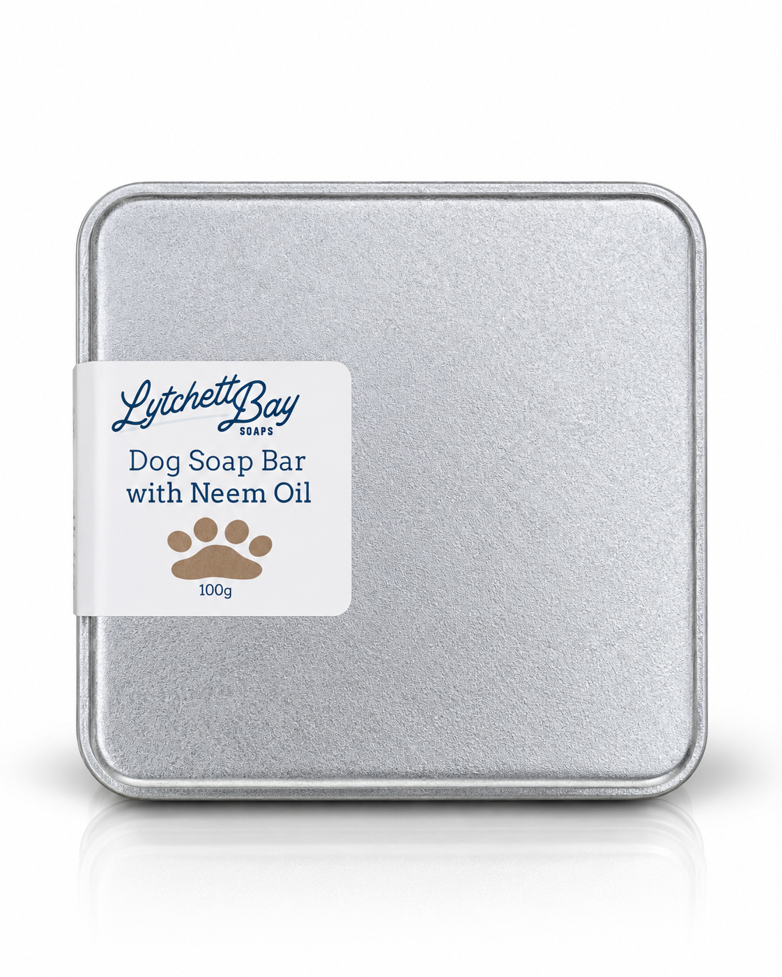 A square silver metal tin of Lytchett Bay Dog Soap Bar with Neem Oil, featuring a white label with blue text and a brown paw print, set against a clean white background with a subtle reflection.
