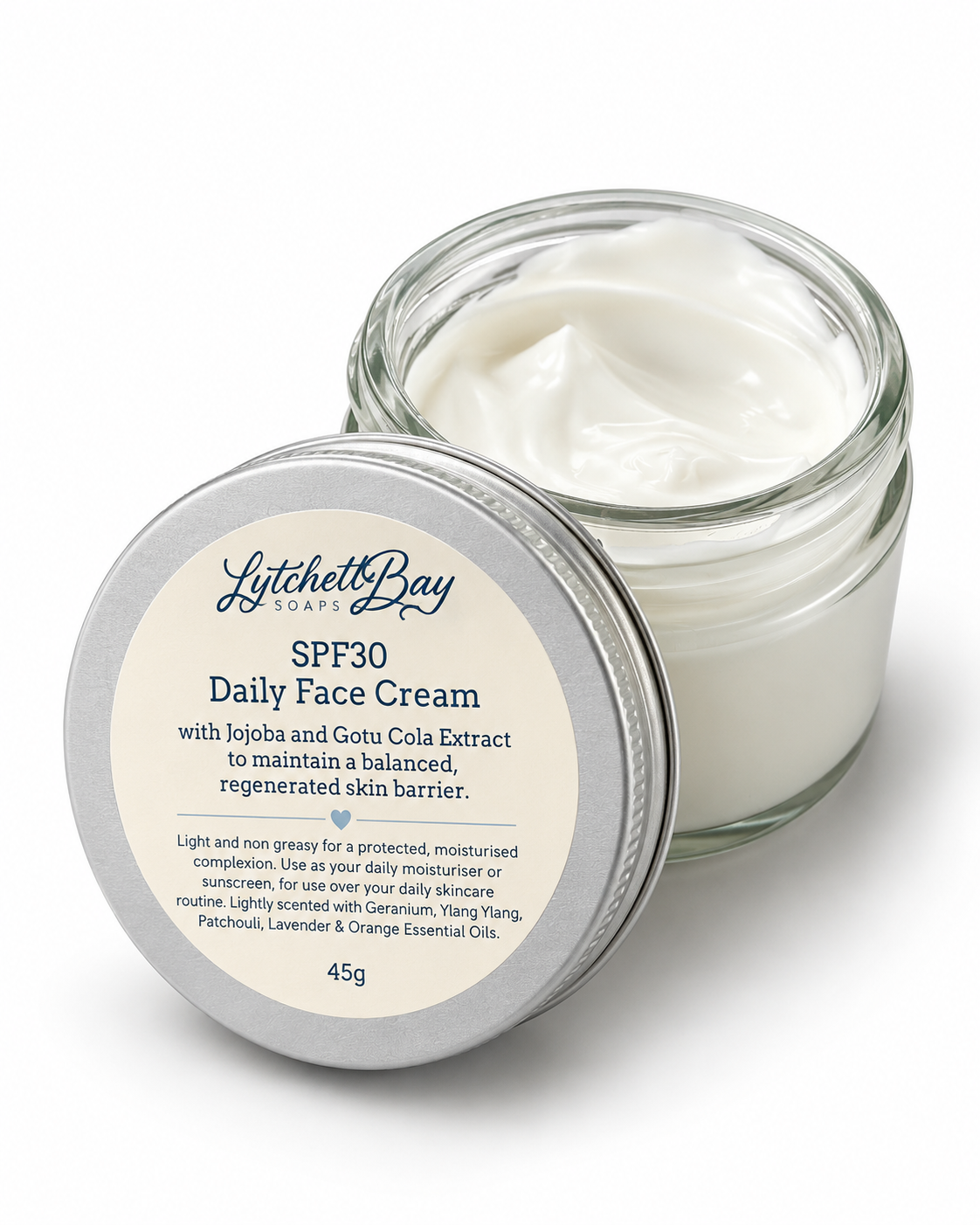 Lyttelton Day SPF30 Daily Face Cream in a clear glass jar with its silver lid in front, showing the white cream inside. The label details the product ingredients and 45g size.