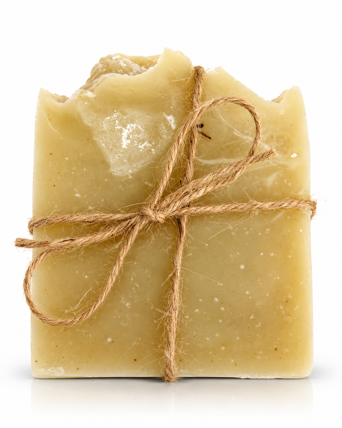 A rectangular bar of handmade soap in a light tan or oatmeal color, wrapped with a rustic brown jute twine bow, set against a plain white background.