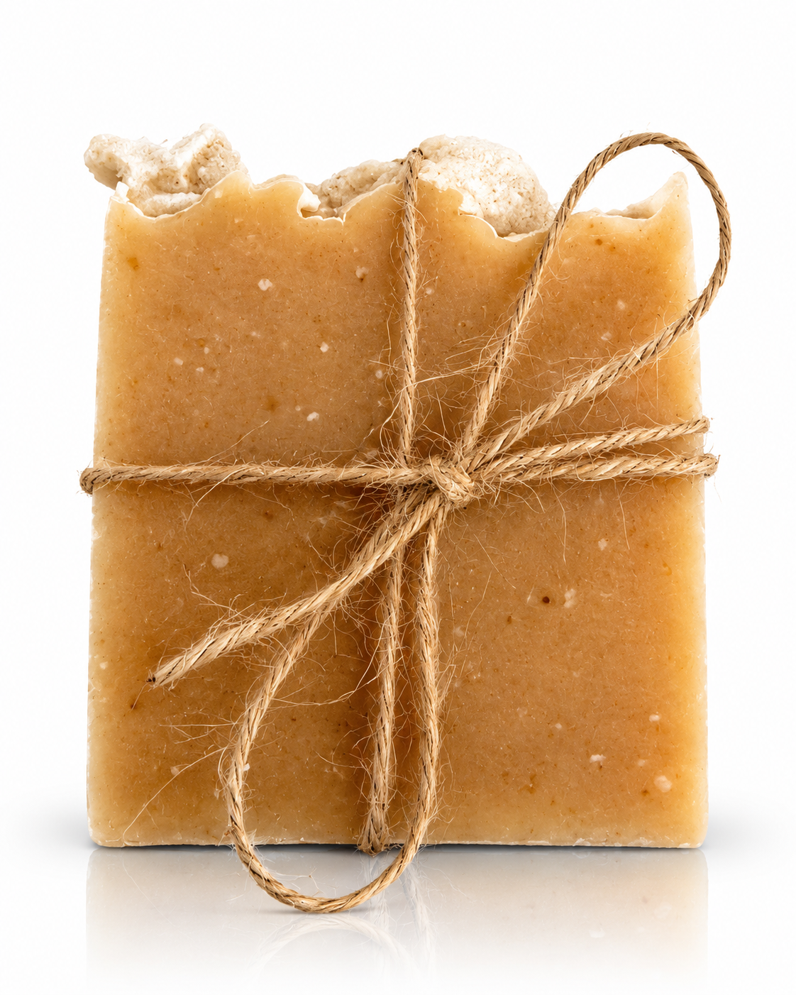 A rustic handmade soap bar in a warm tan-brown color, wrapped in natural jute twine and tied with a bow, set against a clean white background.